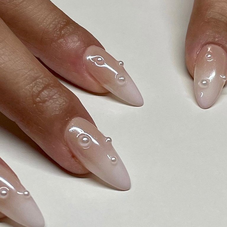 milky white nails with peal embellishments