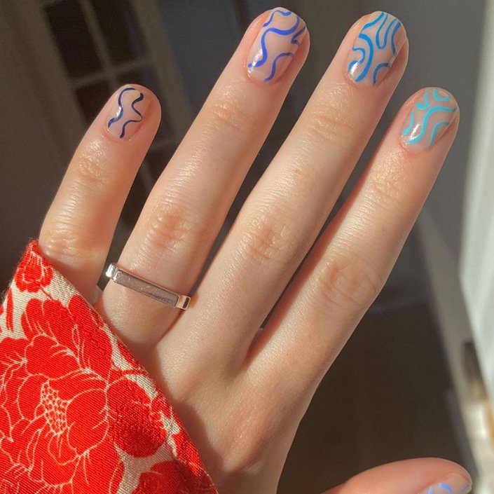 hand with blue squiggles on nails