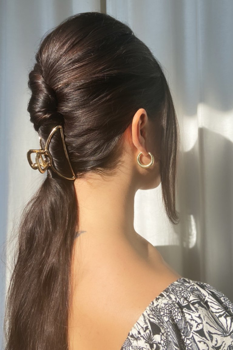 person wearing a sleek twisted ponytail with a claw clip
