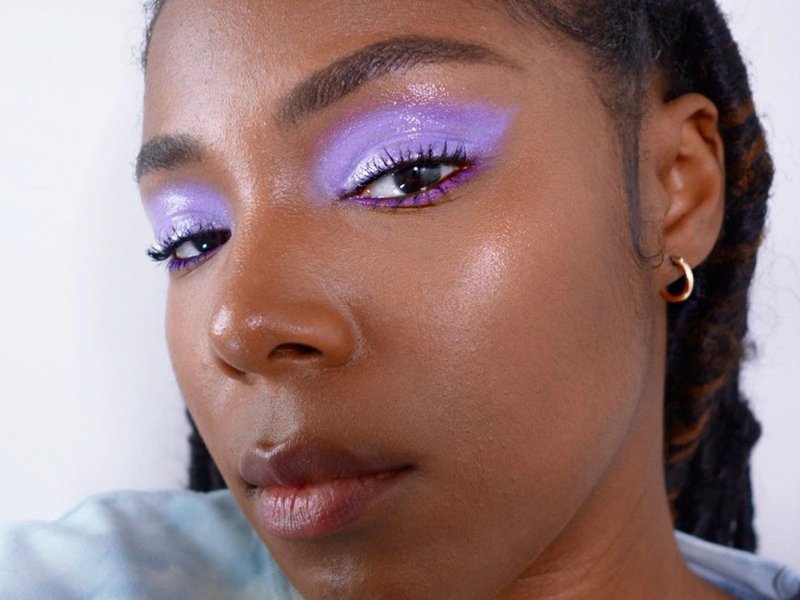 person wearing glossy purple eye makeup