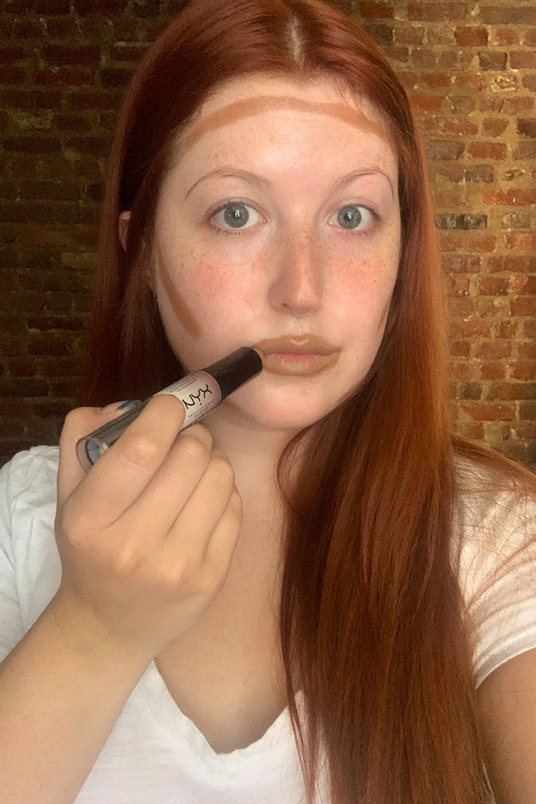 person applying contour stick to lips