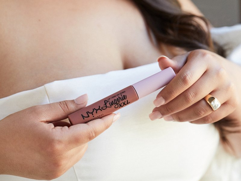 person holding nyx professional makeup xxl lip lingerie liquid lipstick