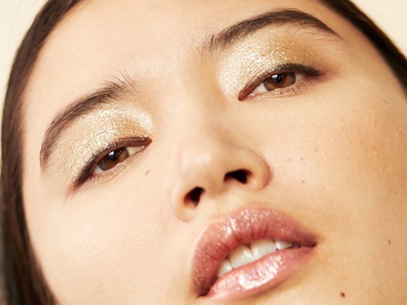 person wearing gold glitter eyeshadow and glitter lip gloss