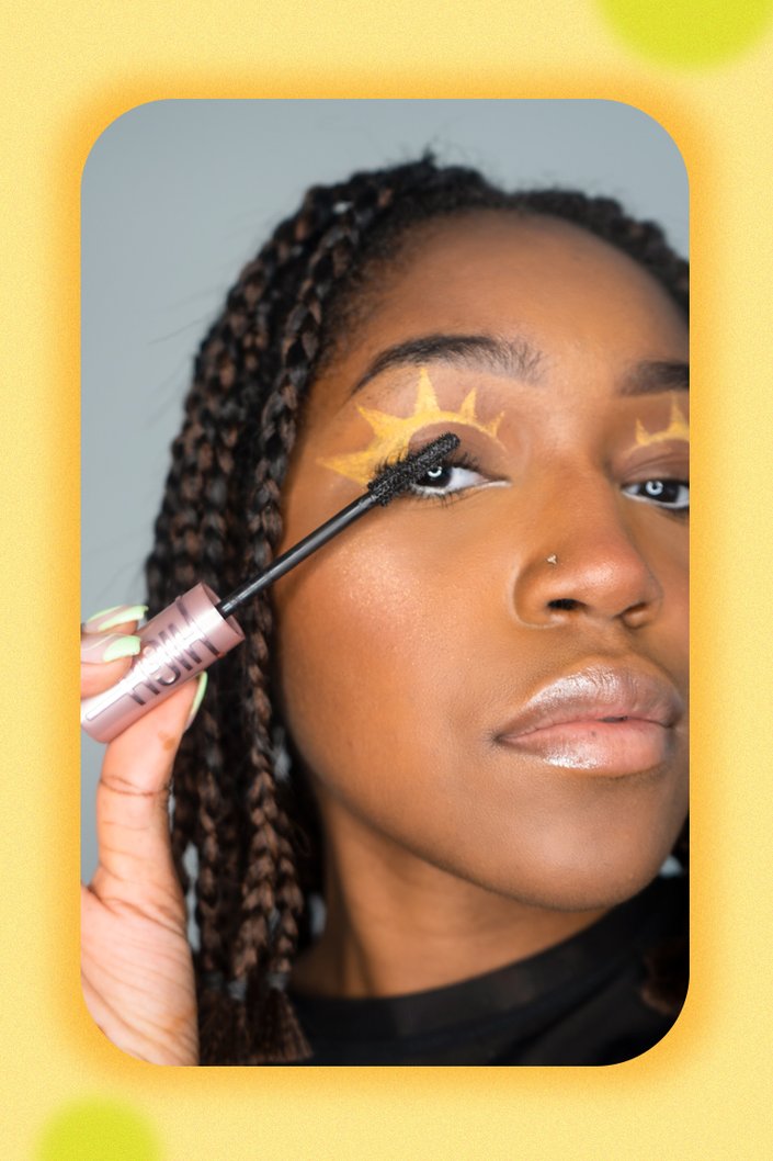 person applying mascara to eyelashes