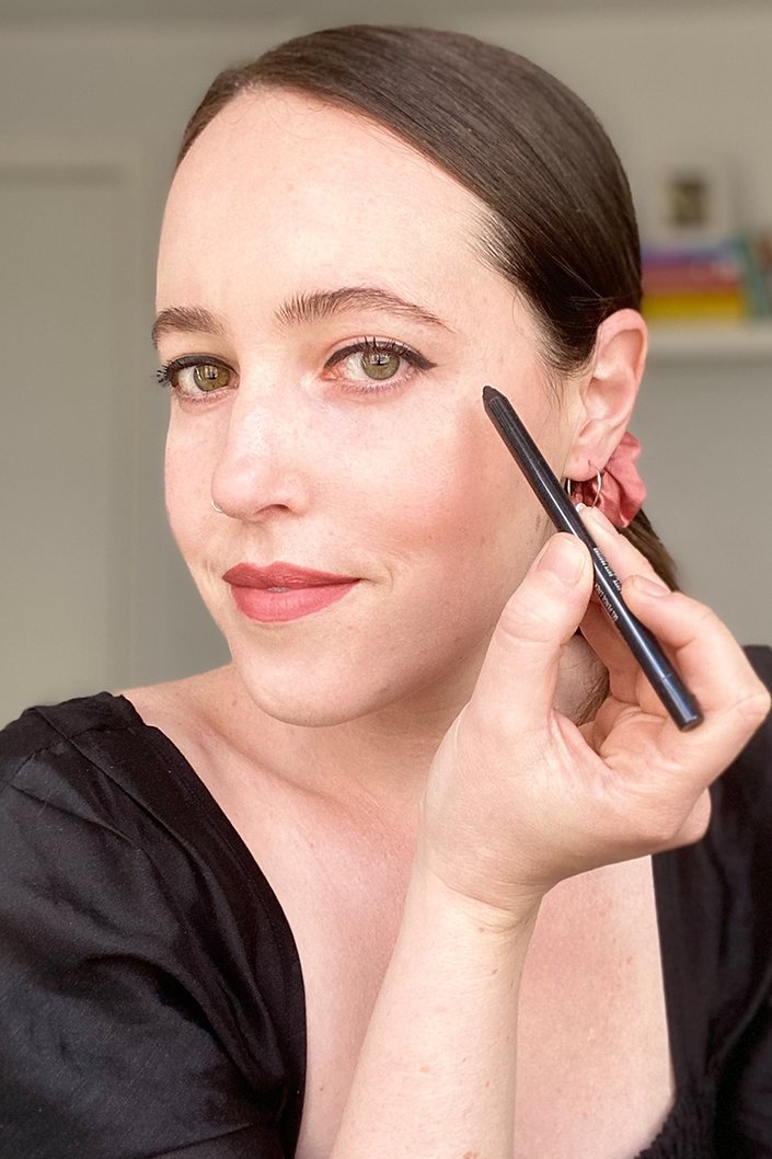 person applying maybelline tattoo studio eye pencil