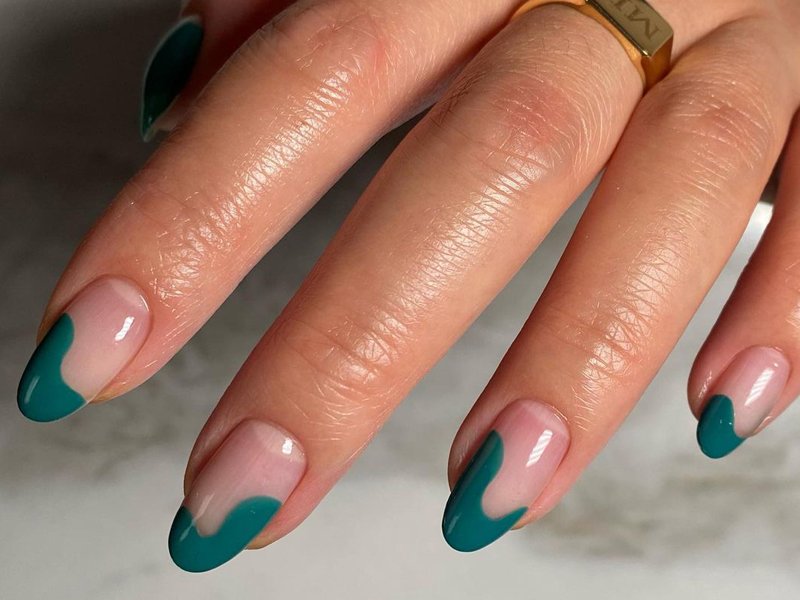 hand with green wavy french manicure on nails