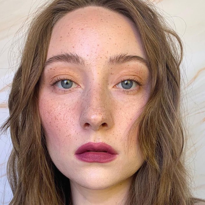 person with red hair and freckles wearing berry lipstick
