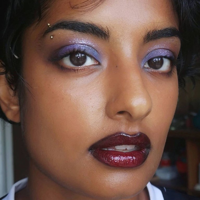 person wearing lavender glitter eyeshadow and burgundy glossy lipstick