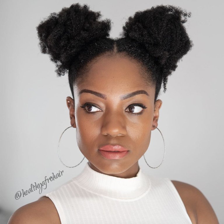 person with kinky hair in two ponytails