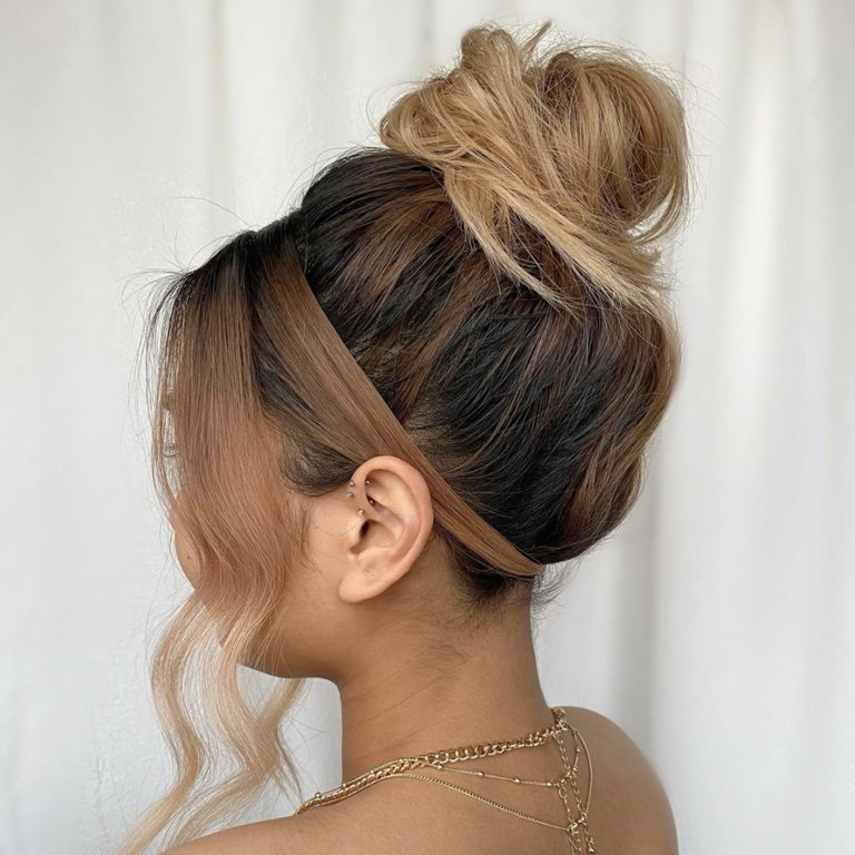 person with messy bun and side bangs