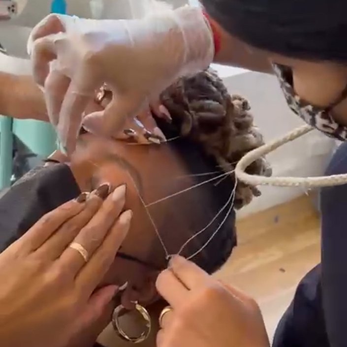 person threading someone's eyebrows