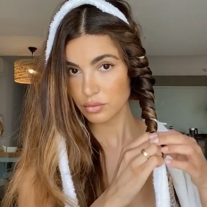 person styling hair with robe belt