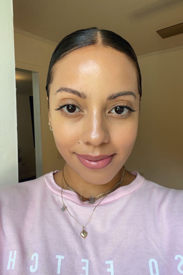 person with middle part and hair pulled back into low bun