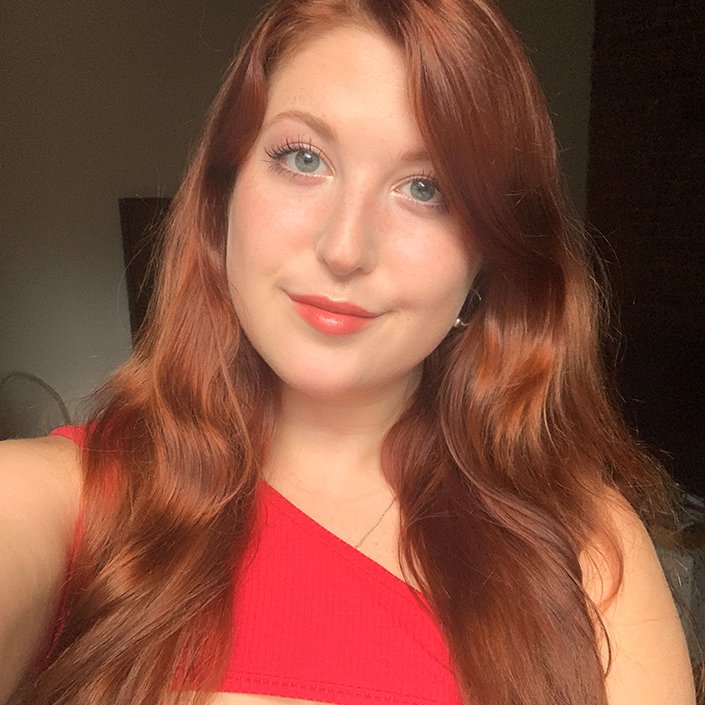 person with red hair wearing natural makeup