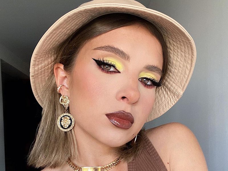 person wearing yellow eyeshadow and brown lipstick
