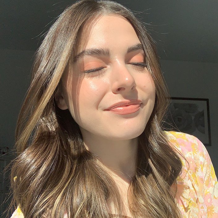 person wearing pastel orange eyeshadow and nude lipstick