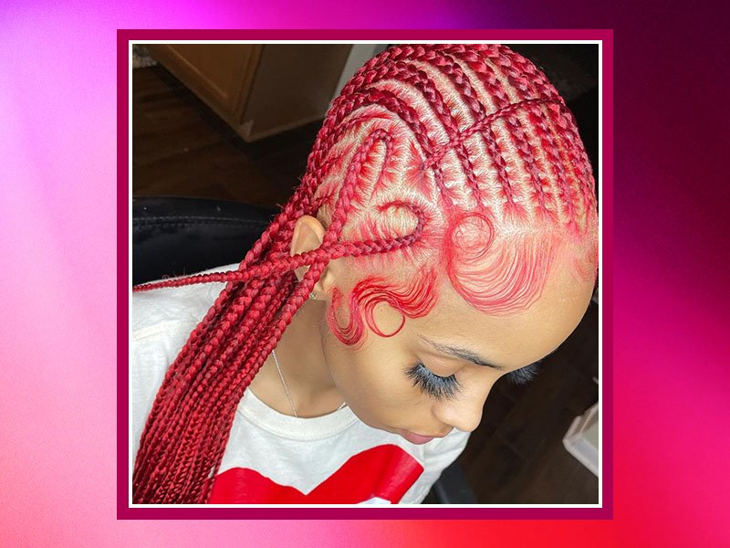 Person with bright red cornrows with a heart design