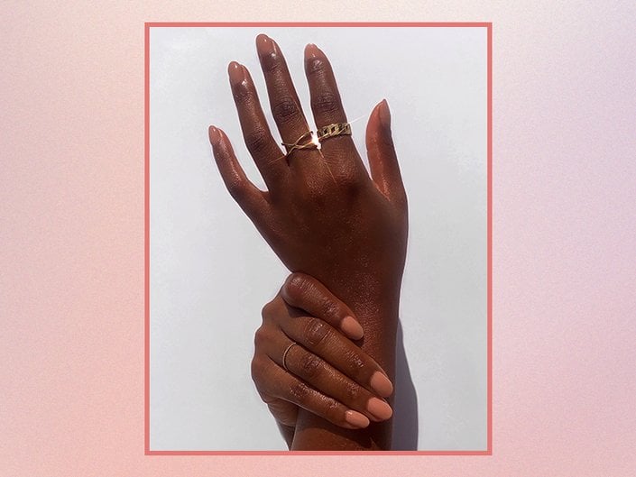 Hands with nude nail polish on a pink gradient background
