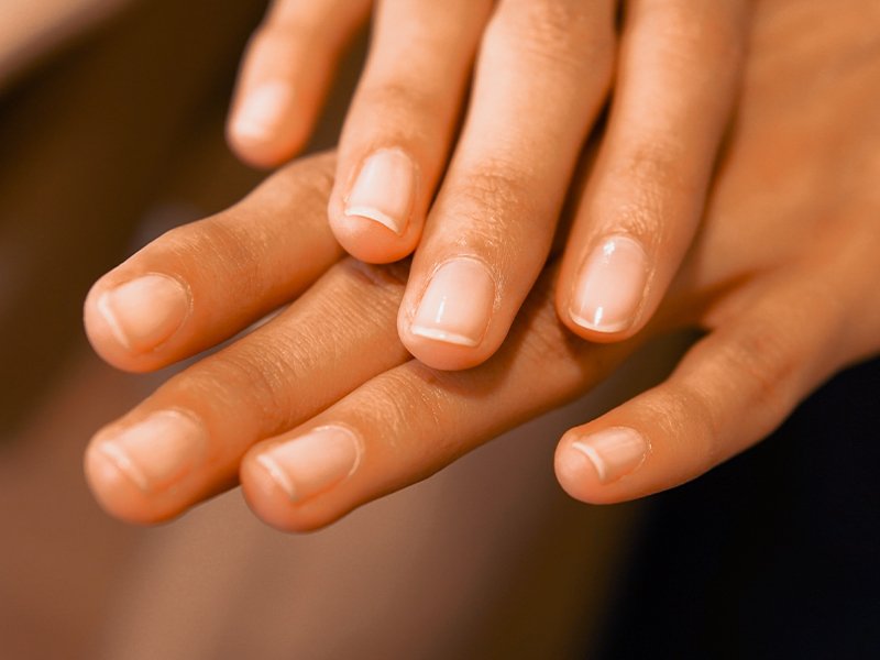 hands with nails wearing sheer nail polish