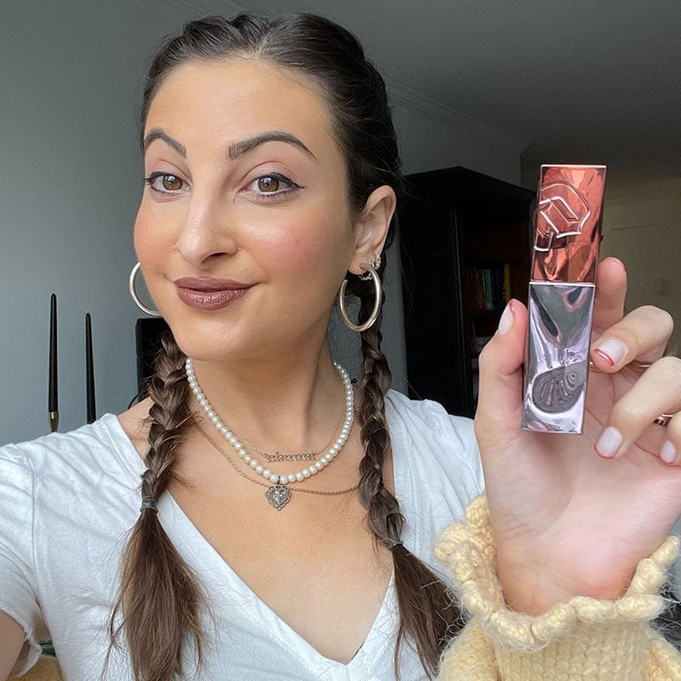 Alanna wears and holds up the Urban Decay Vice Lip Bond Glossy Liquid Lipstick in Law of Attraction