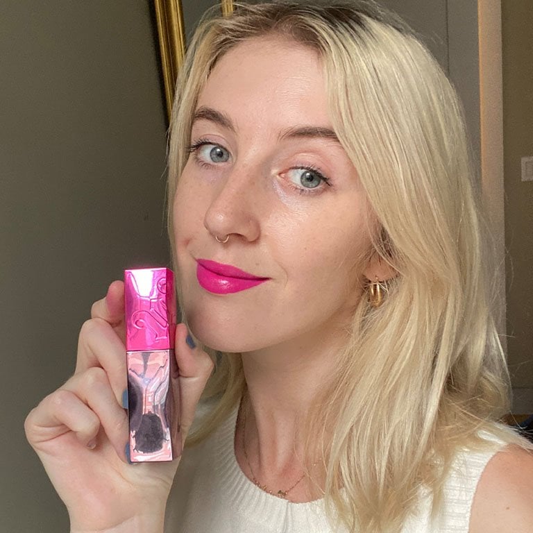 Ariel wears and holds up the Urban Decay Vice Lip Bond Glossy Liquid Lipstick in Shock Value