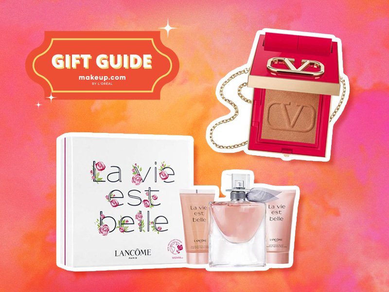 Image of the Valentino Beauty Go-Clutch Refillable Compact Powder and the Lancôme La Vie Est Belle Happiness Set on a pink and orange graphic background with a gift tag that says "Gift Guide"