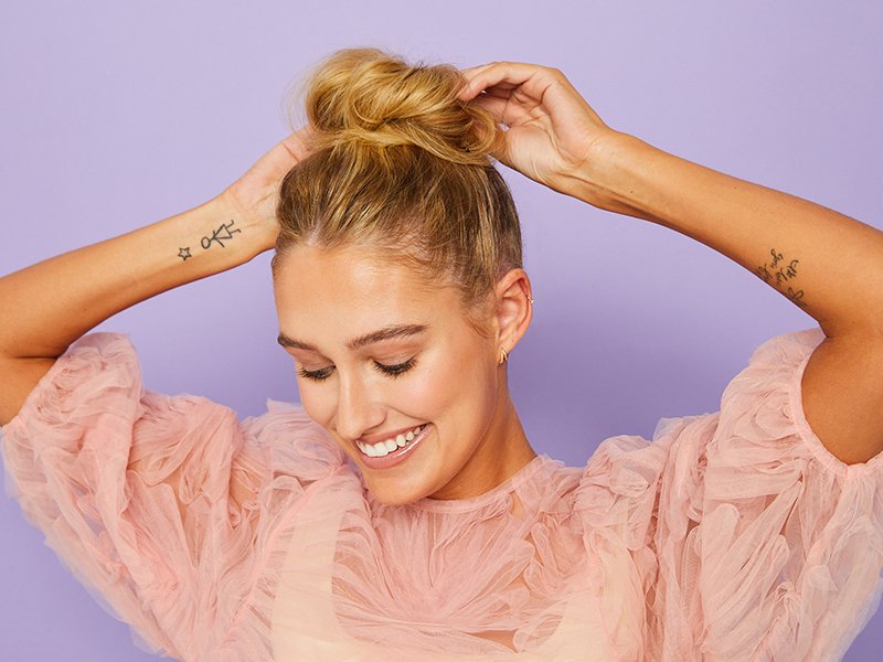 photo of person with messy bun on purple background
