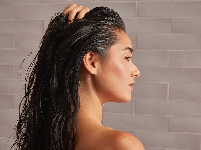 Image of a woman turned in profile, with wet dark hair