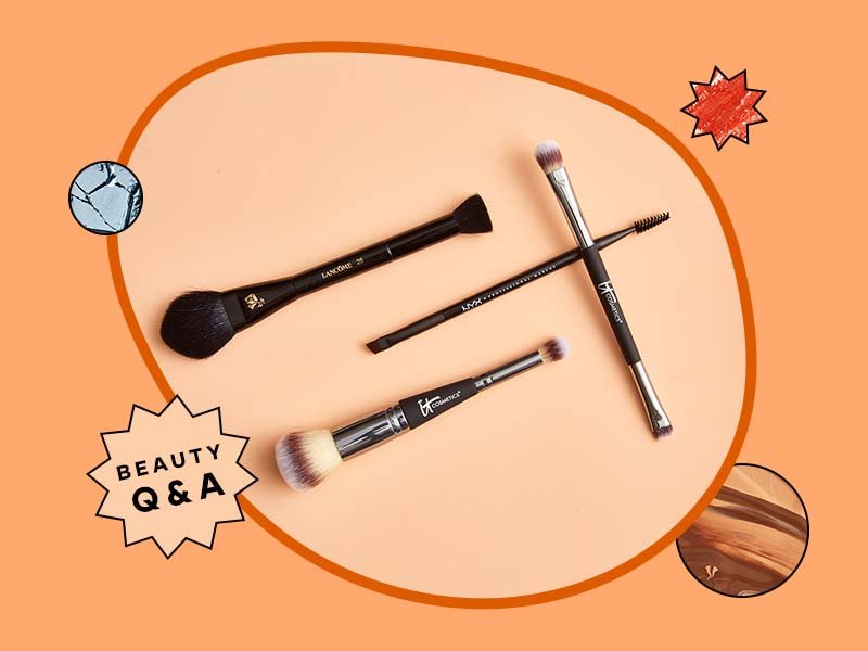 Four makeup brushes on an orange background.