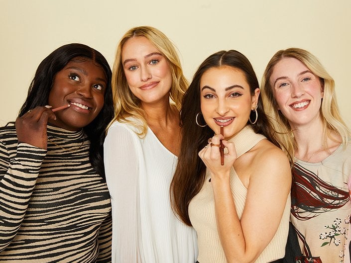 Photo of four smiling women wearing brown lip liner