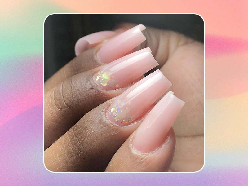 Image of nude polygel nails with glitter on a pastel background