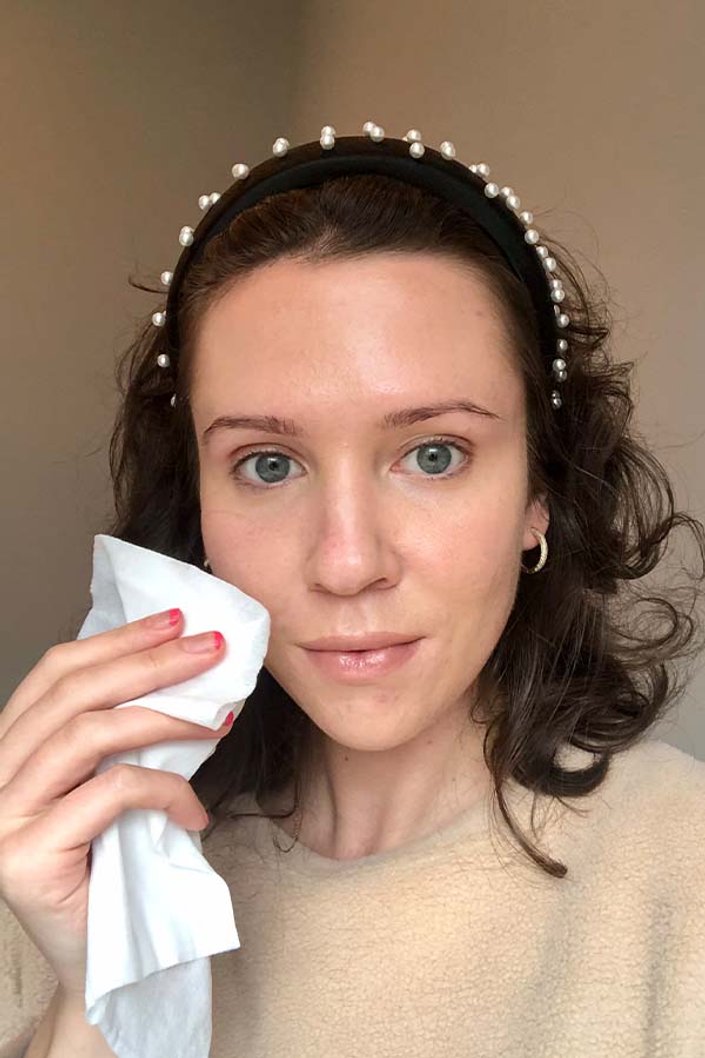 person holding makeup removing wipe to face