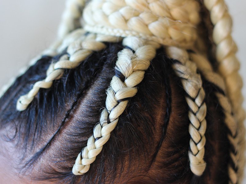 Close-up photo of black and blonde cornrows in a bun