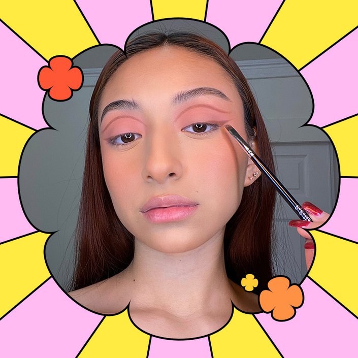 person applying brown eyeshadow to eyelid with makeup brush