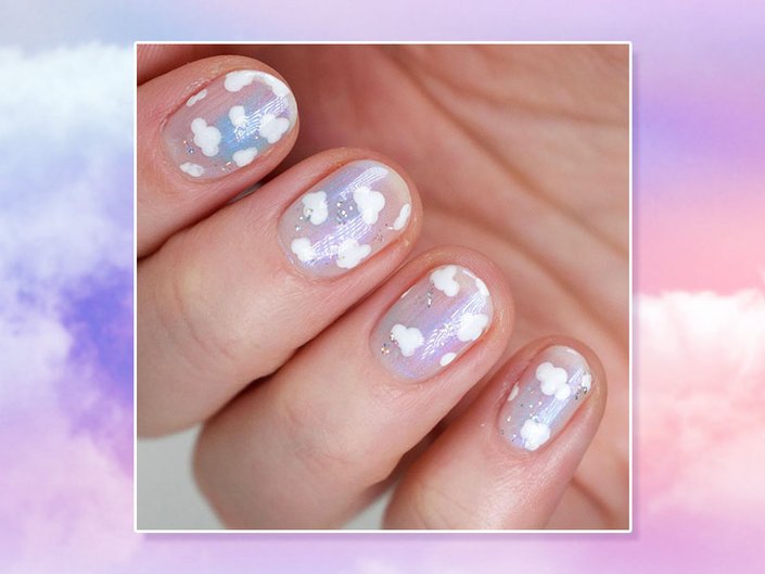 hand with cloud nail art on nails