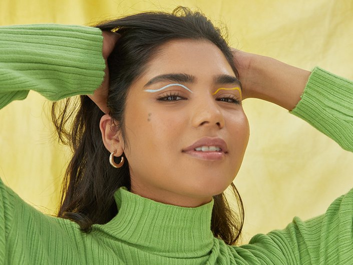 person posing with hands in hair and looking into camera