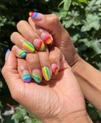 Photo of hands with nails painted with a rainbow tie-dye design