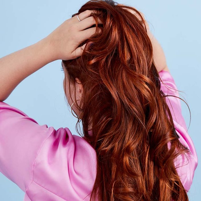 person with long red hair turned away from camera