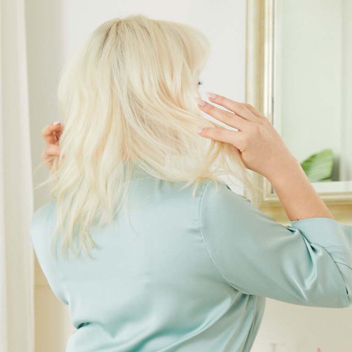 person with shoulder length blonde hair turned away from camera