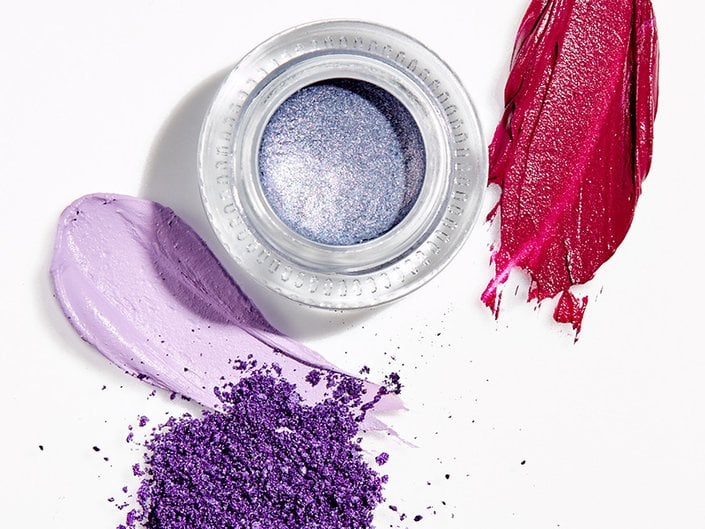 overhead picture of swatches of pink and purple makeup and a pot of sparkly lavender eyeshadow