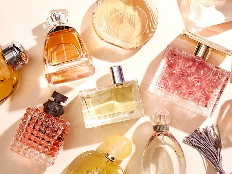 An assortment of perfumes on a cream background