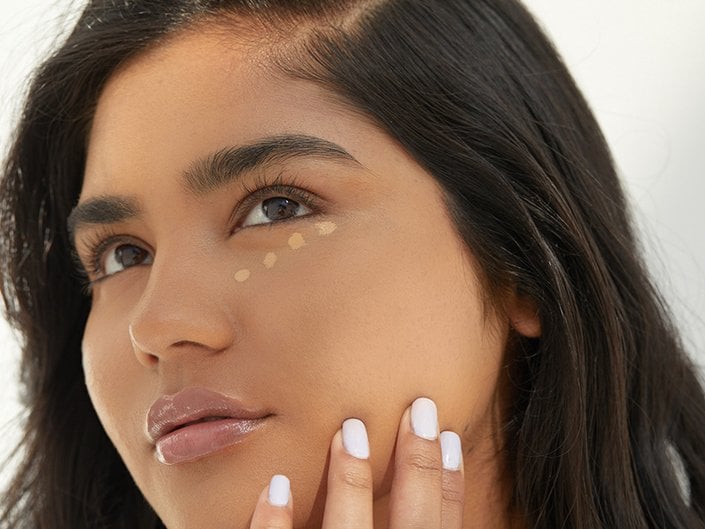 Person with concealer dotted under their eyes
