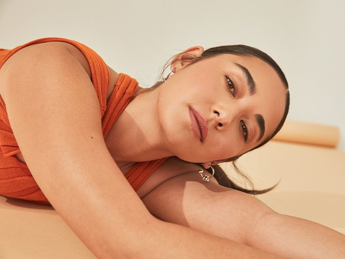 Image of woman lying on her side looking at the camera