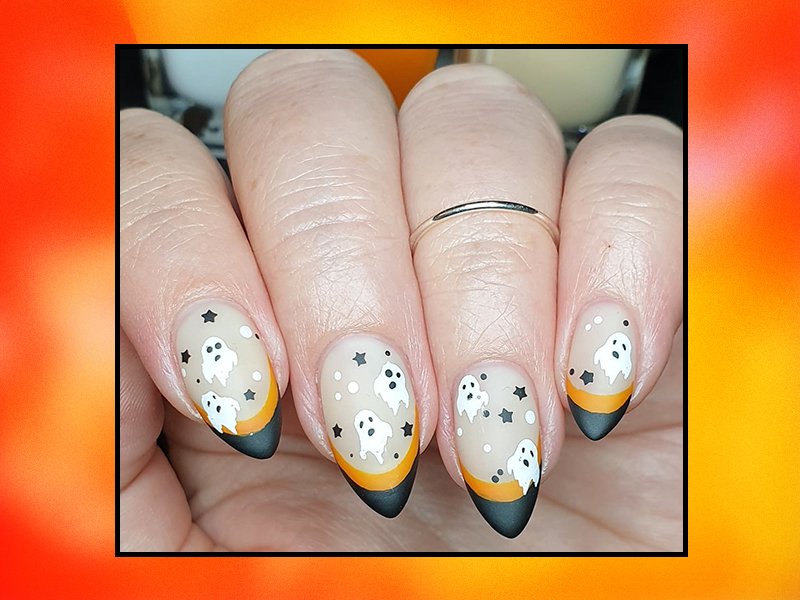 hands with ghost halloween nail art on nails