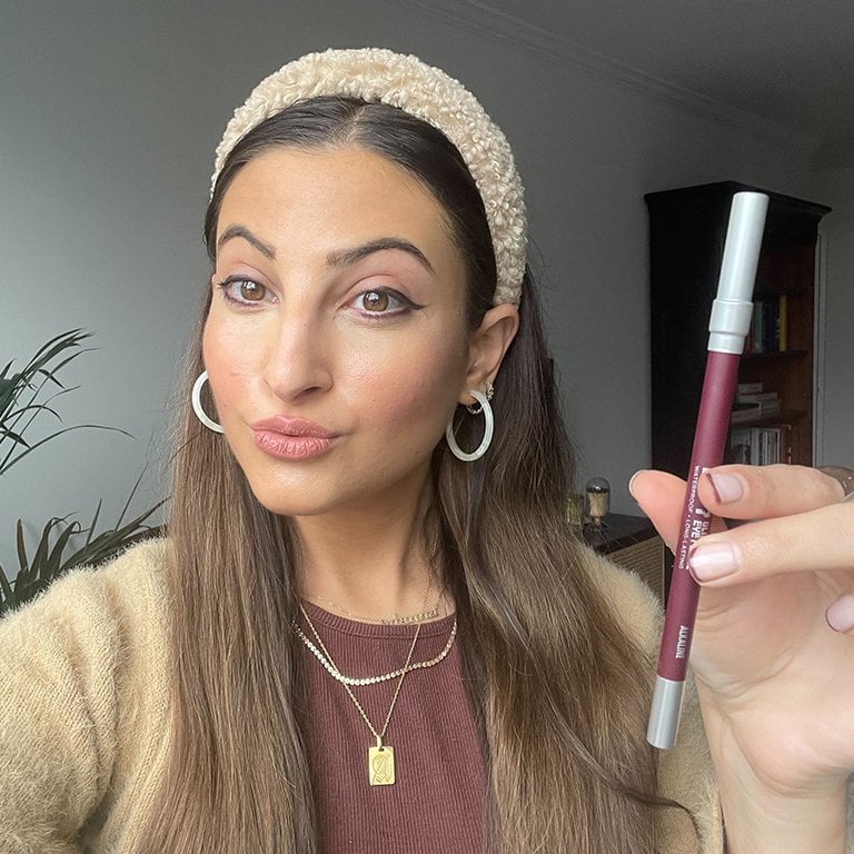 Image of a woman holding the Urban Decay 24/7 Glide-On Waterproof Eye Pencil in Alkaline