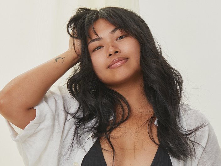 Person with wavy black hair and bangs