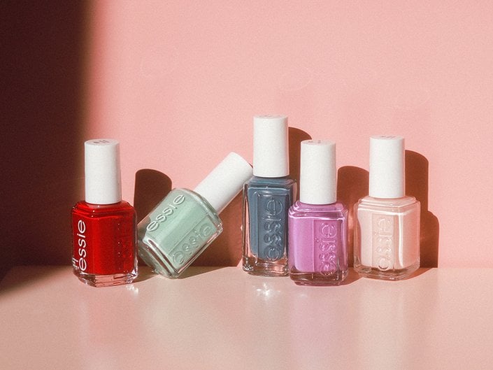 Picture of multiple Essie nail polishes on a light pink background