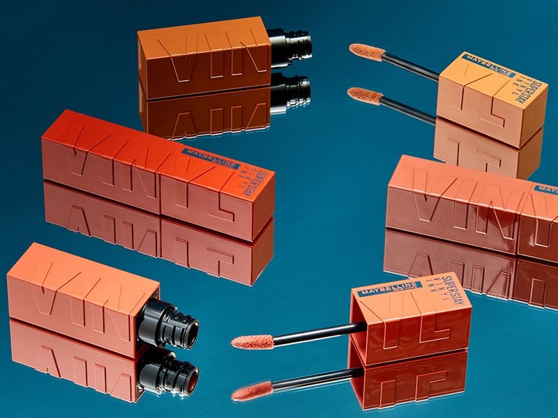 Photo of the Maybelline New York Super Stay Vinyl Ink Liquid Lipcolors on a teal background 