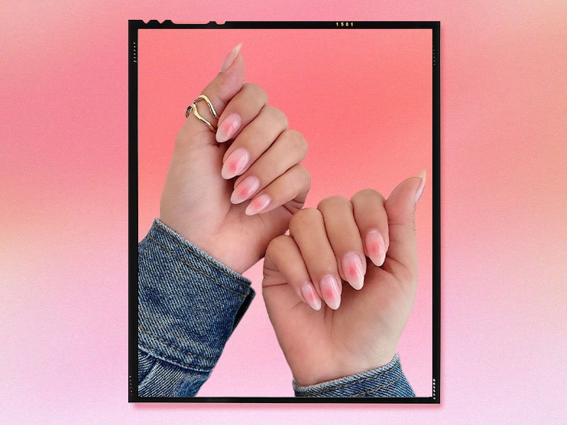 person's hands with their nails painted light pink with a darker pink blush design in the centers