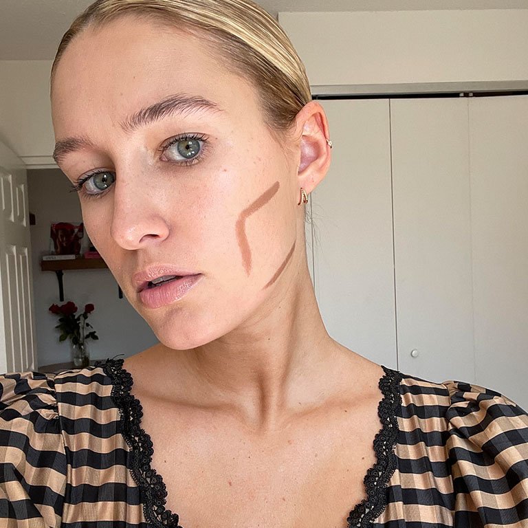 selfie of editor with contour makeup drawn in a curved line along her cheekbone and jaw